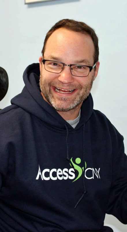 A smiling white man in an AccessCNY hoodie