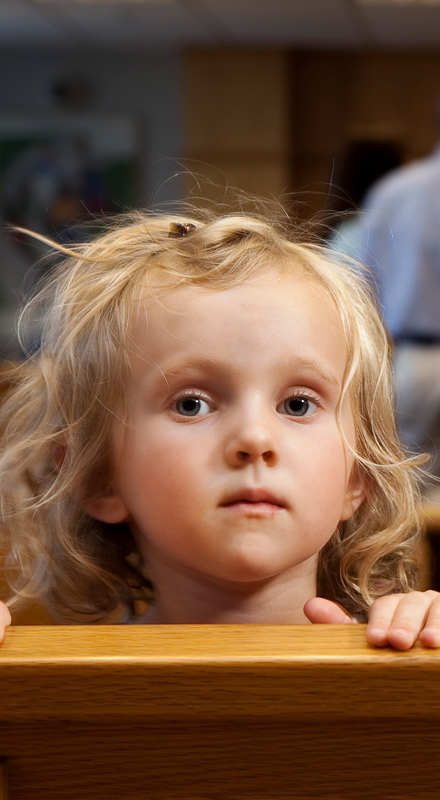 young blonde girl looking sad and staring at camera