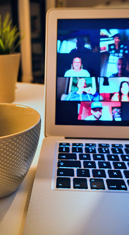 A coffee cup, a plant and a videocall on a MacBook